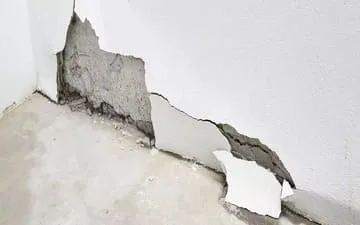 O que é seguro de imóvel comercial? Na imagem, parede de uma empresa danificada em alusão à importância de fazer o seguro patrimonial empresarial.