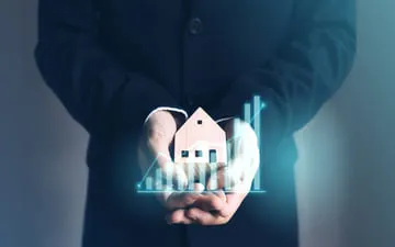 O que é o seguro patrimonial empresarial? Na imagem, mãos segurando um imóvel comercial em alusão à importância do seguro de bens para empresas.