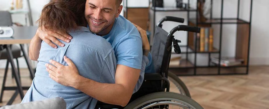 Qual seguro cobre invalidez por doença? Na imagem, homem abraça esposa evidenciando a importância do suporte de um seguro de vida invalidez por doença