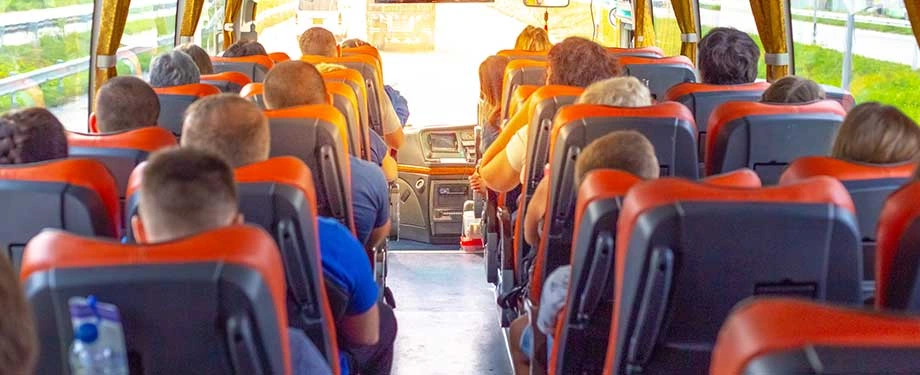Quanto custa um seguro APP de passageiros? Na imagem, passageiros sentados em &ocirc;nibus evidenciam seguro, cujo valor depende de fatores como hist&oacute;rico de sinistros e tipo de opera&ccedil;&atilde;o 