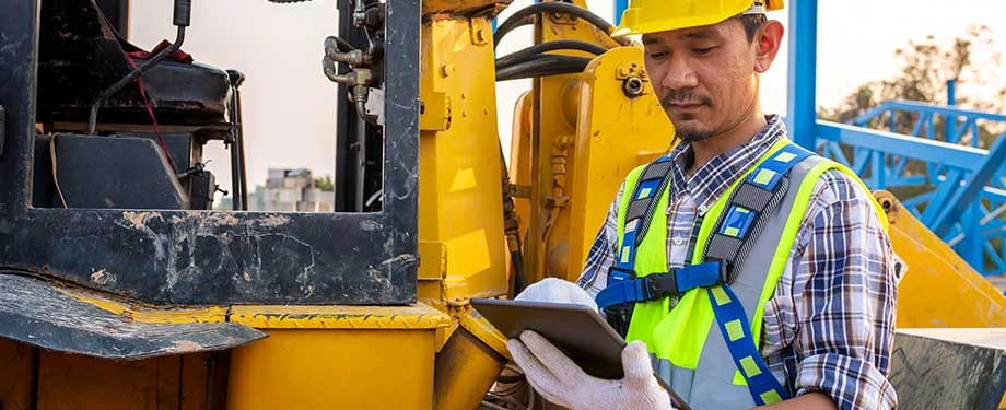 O que cobre o seguro de equipamentos? Na imagem, profissional ao lado de equipamento representa seguro que oferece cobertura para danos causados em loca&ccedil;&atilde;o  