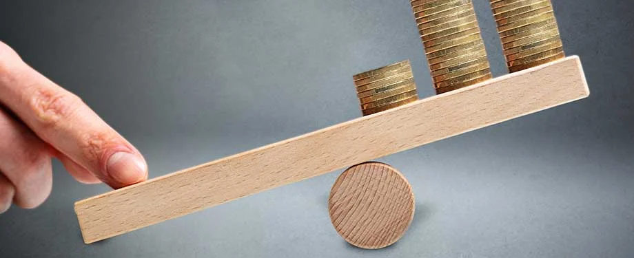 O que &eacute; uma cl&aacute;usula stop loss? Na imagem, moedas sendo equilibradas representam o seguro stop loss, que visa assegurar a estabilidade da opera&ccedil;&atilde;o 