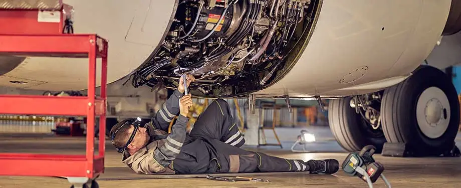 Qual o valor do seguro avião? Na imagem, profissional conserta aeronave após indenização do seguro
