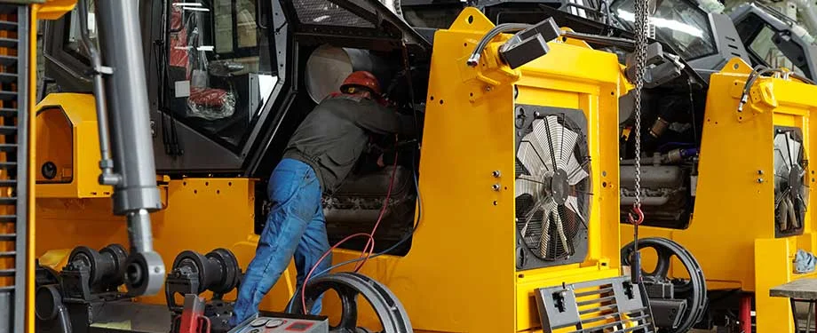 Como contratar o seguro de m&aacute;quinas e equipamentos? Na imagem, profissional fazendo manuten&ccedil;&atilde;o de m&aacute;quina em alus&atilde;o ao seguro de m&aacute;quinas e equipamentos, que pode ser contratado com aux&iacute;lio de um corretor de seguros 