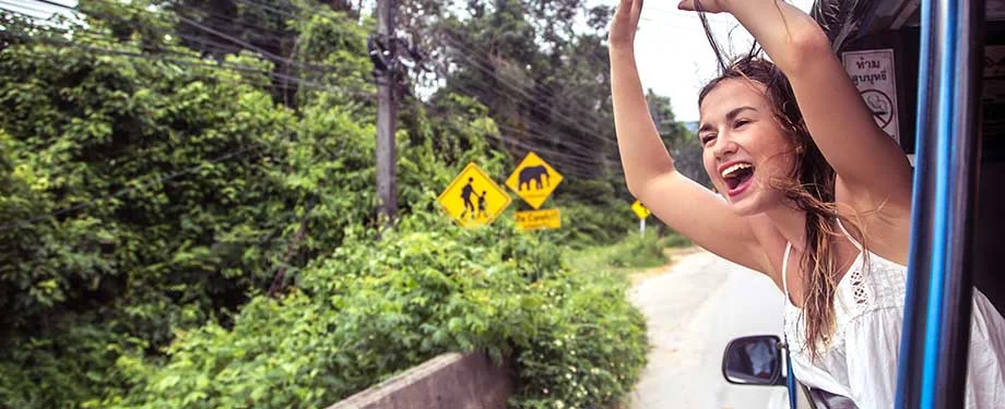 Como contratar o seguro excursão para empresas? Na imagem, turista animada em representação ao seguro excursão para empresas, que pode ser contratado de forma digital