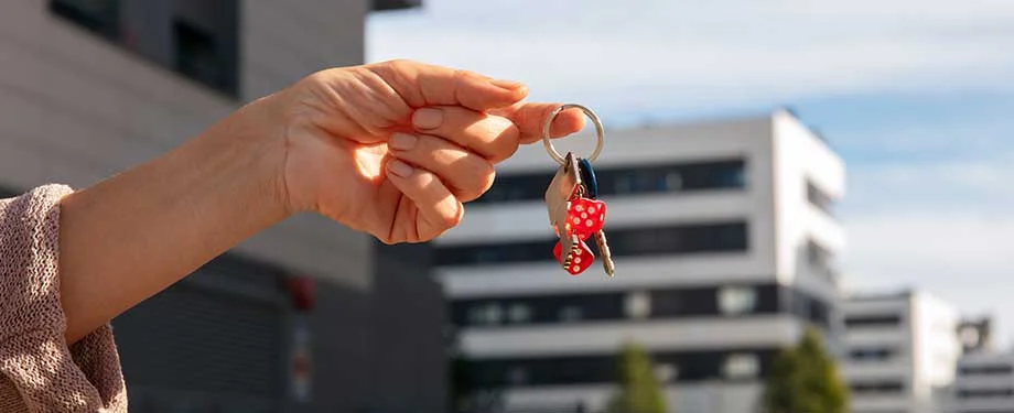 O que cobre o seguro do condomínio? Na imagem, pessoa segurando chave de apartamento em alusão ao seguro multirriscos condomínio, que protege o patrimônio e a estrutura física