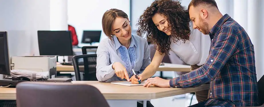 Como contratar o seguro para escrit&oacute;rio? Na imagem, dona de empresa assina contrato de seguro para escrit&oacute;rio com aux&iacute;lio de corretores de seguros 