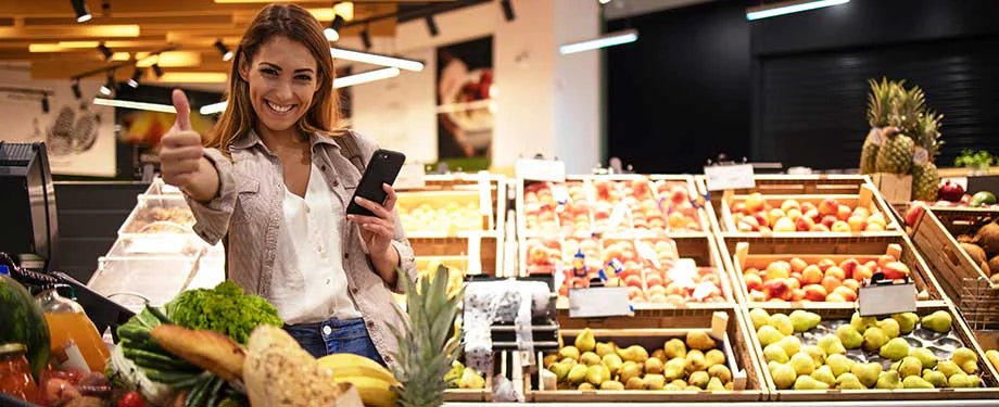 Qual é o preço do seguro para comércio? Na imagem, consumidora fazendo compras reforça a importância do seguro supermercado para a continuidade das operações