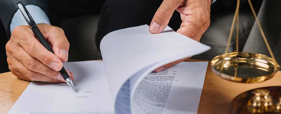 Como contratar um seguro de responsabilidade civil geral? Na imagem, dono de empresa assina apólice após contatar corretora de seguros para auxiliar na contratação do seguro