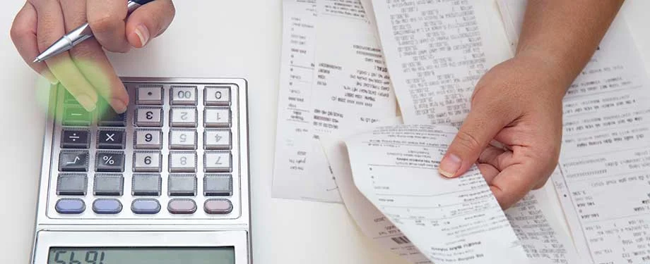 O que &eacute; CST na nota fiscal? Na imagem, pessoa calculando valores identificados nas notas fiscais em alus&atilde;o ao c&oacute;digo de 3 d&iacute;gitos que indica o tipo de tributa&ccedil;&atilde;o 