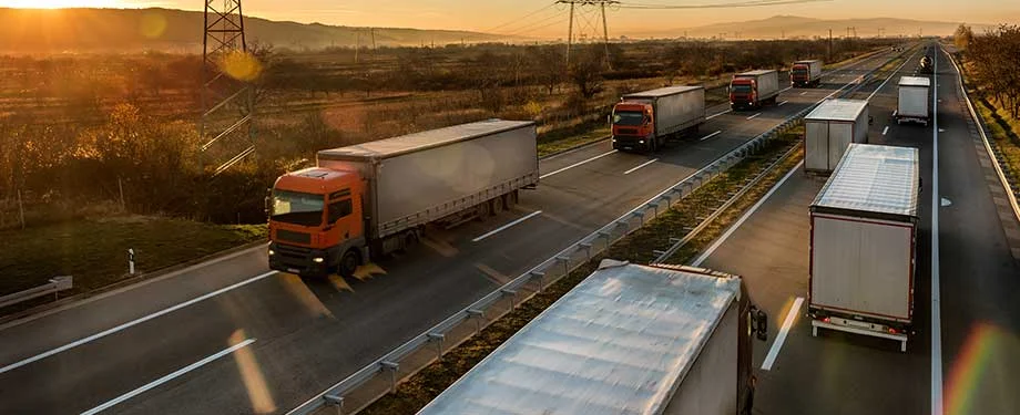 Como posso fazer a revalidação ordinária da ANTT? Na imagem, caminhões transportando mercadorias em alusão a atualização cadastral ANTT, que pode ser feita pelo RNTRC Digital