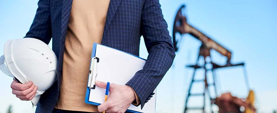 Como funciona o seguro de riscos de petróleo? Na imagem, engenheiro segura capacete e prancheta, representando o seguro petróleo, que funciona como uma proteção contra danos materiais e operacionais