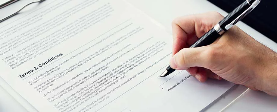 Qual o valor do seguro garantia contratual? Na imagem, pessoa assinando contrato representa importância do seguro garantia contratual, cujo prêmio depende do valor a ser garantido pela apólice