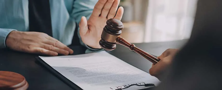 É possível substituir penhora por seguro garantia? Na imagem, contrato e martelo da justiça representam o seguro garantia judicial, que funciona como substituto da penhora de bens