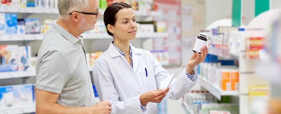 Como funciona o seguro para farmácias? Na imagem, farmacêutica em atendimento representa a apólice que cobre riscos relacionados a danos ao estabelecimento e à responsabilidade civil