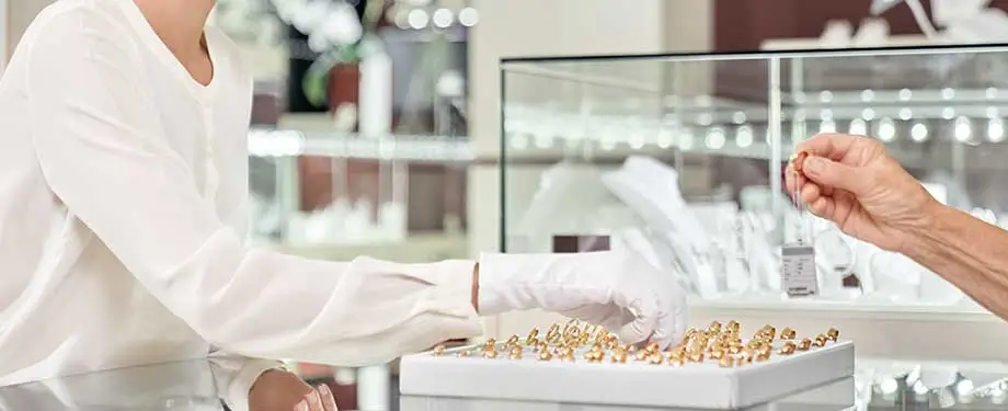 Quanto custa um seguro de joias? Na imagem, vendedora organiza anéis que são protegidos com seguro para joias 