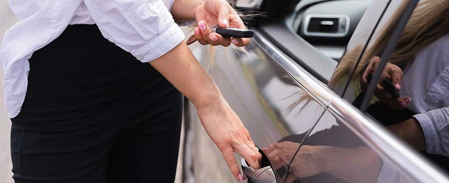 Como funciona uma seguradora de carro? Na imagem, mulher segurando a chave de seu automóvel representa a importância de contratar o seguro com uma seguradora de carro de confiança