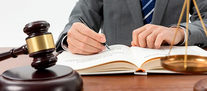 Qual a diferença entre pregão e licitação? Na imagem, advogado, martelo e balança da justiça em alusão à diferenciação entre os termos pregão e licitação