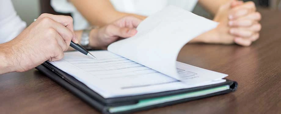 Quais são as garantias de um contrato? Na imagem, prestador de serviço confere as condições do contrato que irá assinar