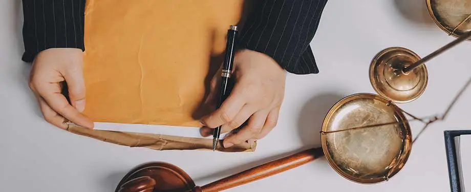 Erro material pode ser corrigido a qualquer tempo? Na imagem, homem com envelope e caneta representa a possibilidade de correção do erro material a qualquer momento