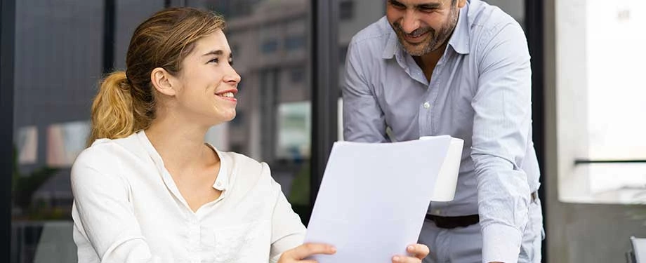 O que é RC Empresa? Na imagem, corretora e dono de empresa conversam sobre importância do Seguro de Responsabilidade Civil Empresarial