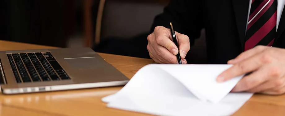 O que a Lei 14.133 estabelece? Na imagem, profissional assinando documentação representa a Nova Lei de Licitações, que atualizou as normas para a realização de licitações