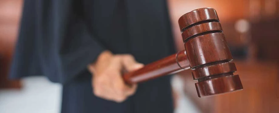 O que acontece quando ocorre um bloqueio judicial? Na imagem, juiz segura martelo da justiça para determinar bloqueio judicial