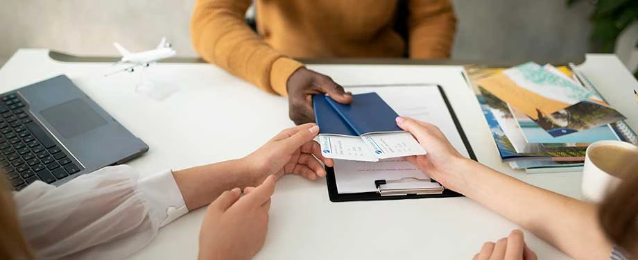 Como saber se o seguro viagem é confiável? Na imagem, pessoas entregam passaporte e comprovante de seguro viagem da Assist Card para entrar em território internacional