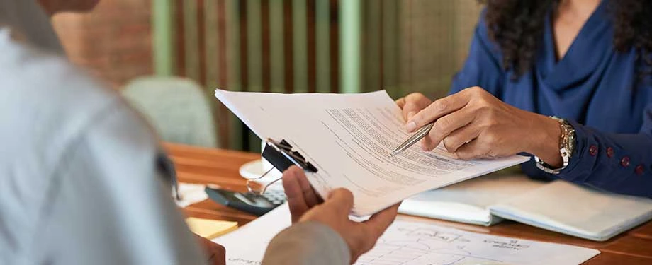 O que são condições gerais de um contrato? Na imagem, segurado assina apólice de seguro após ler as condições gerais