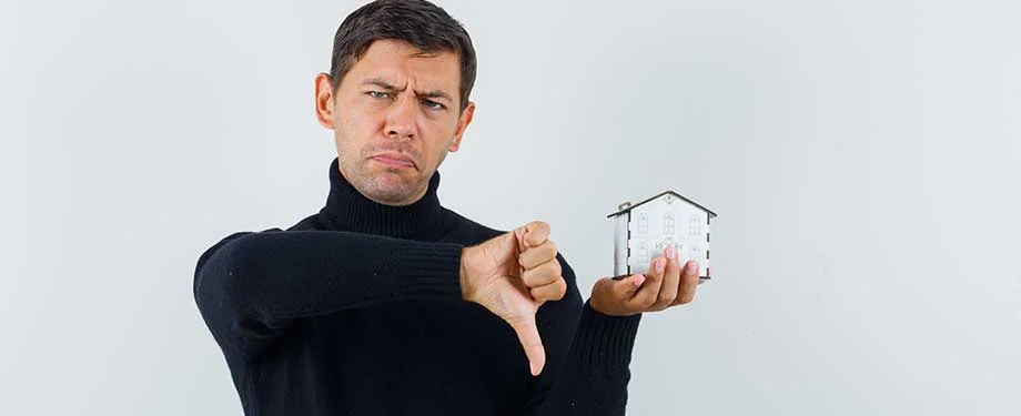 Como se livrar da penhora de bens? Na imagem, homem segurando imóvel representa os pontos negativos da penhora de bens, que pode ser substituída por outras formas de garantias
