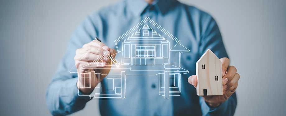 Quais as vantagens do seguro garantia permuta imobiliária? Na imagem, homem desenha símbolo de casa em alusão ao seguro garantia, que pode assegurar o cumprimento das condições acordadas em uma permuta imobiliária