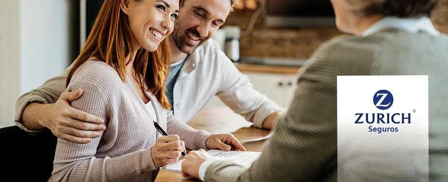 Como funciona o seguro Zurich? Na imagem, casal sorridente assina apólice de seguro da Zurich