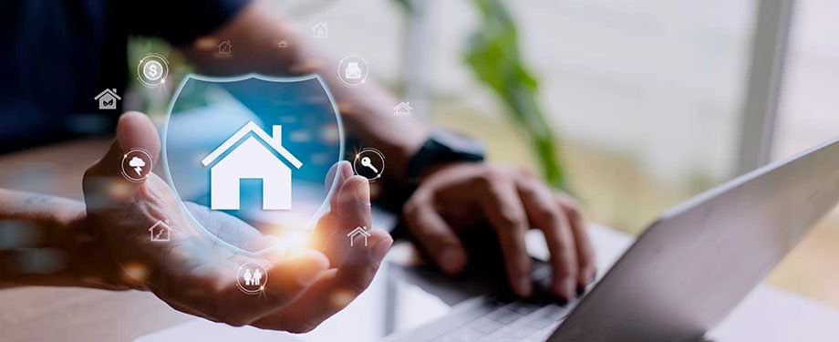 Qual é o preço médio de um seguro residencial? Na imagem, homem segura escudo com casa em alusão às melhores seguradoras residenciais