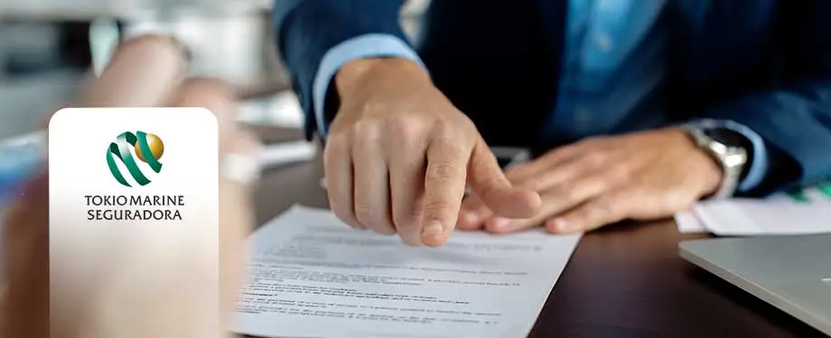 Quais os benefícios do seguro Tokio Marine? Na imagem, homem lê condições gerais de seguro Tokio Marine e entende por que contratar
