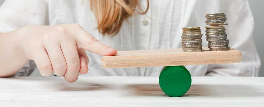 Como emitir depósito judicial? Na imagem, mulher equilibra moedas em alusão ao uso do depósito judicial como garantia e seus riscos envolvidos