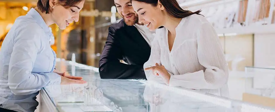 O que o seguro para joias cobre? Na imagem, casal em joalheria escolhe anel, evidenciando a importância da contratação do seguro de joias 