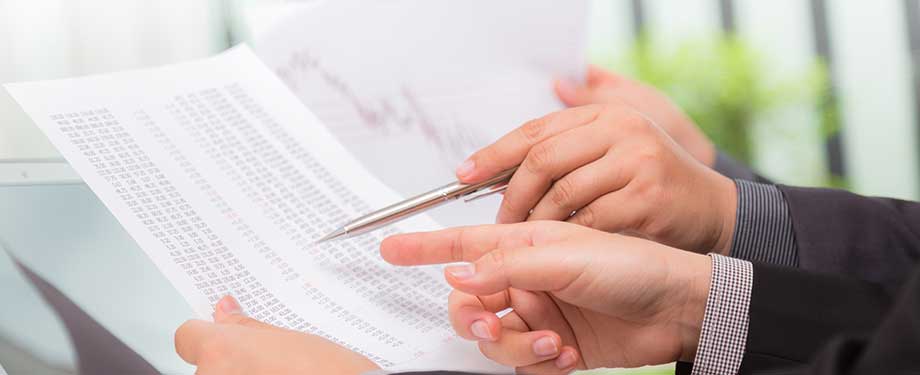 O que significa reequilíbrio econômico-financeiro? Na imagem, profissionais analisando papelada com dados a fim de chegar a um acordo balanceado para as duas partes