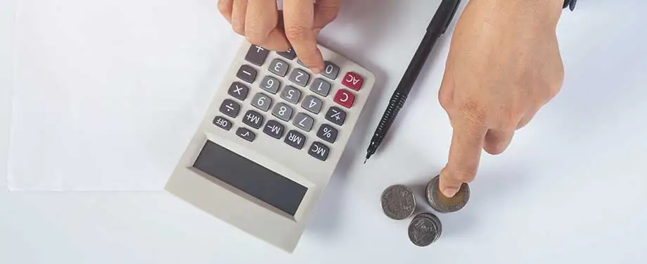 Como funciona o processo de execução fiscal? Na imagem, pessoa segura moedas e faz cálculos, evidenciando medidas de cobranças dispostas pela Lei de Execução Fiscal