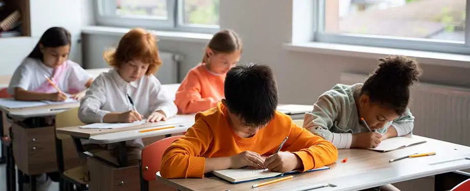 O que cobre o seguro de responsabilidade civil escolar? Na imagem, crianças em sala de aula evidenciam a importância do seguro para cobrir situações como acidentes, incêndios e explosões 