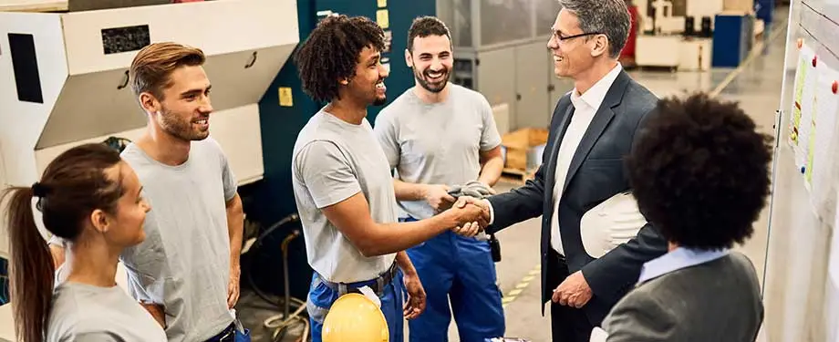 O que é um RC de uma empresa? Na imagem, empregador aperta a mão de funcionário em alusão ao compromisso que possuem no trabalho