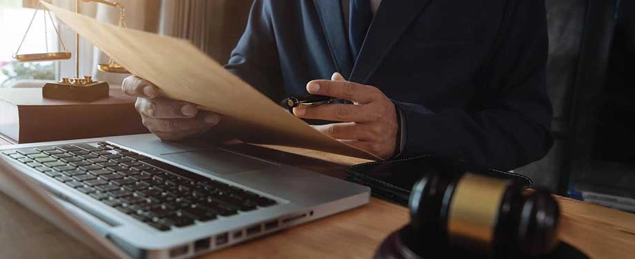 Quanto tempo demora para julgar um agravo de peti&ccedil;&atilde;o? Na imagem, homem com papelada, computador e martelo da justi&ccedil;a evidencia que n&atilde;o h&aacute; um prazo para esse tipo de recurso 