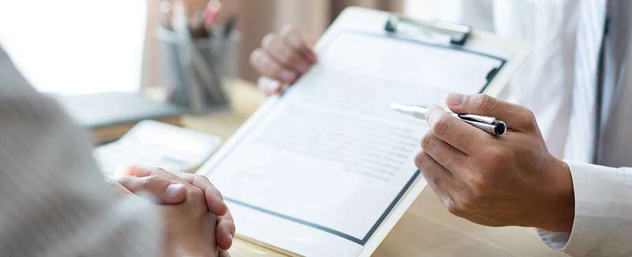 O que significa apólice de seguro compreensiva? Na imagem, corretor de seguros mostra apólice de seguro compreensivo, que inclui uma gama de opções de coberturas