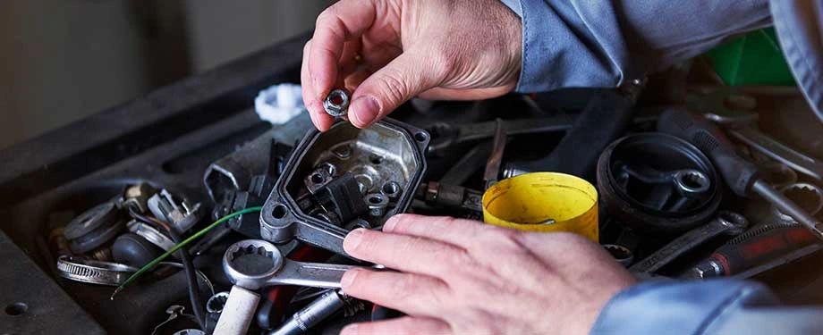 Qual a import&acirc;ncia de fazer o seguro garantia mec&acirc;nica? Na  imagem, mec&acirc;nico fazendo ajustes em motor em alus&atilde;o &agrave; import&acirc;ncia de contar com a cobertura do seguro 