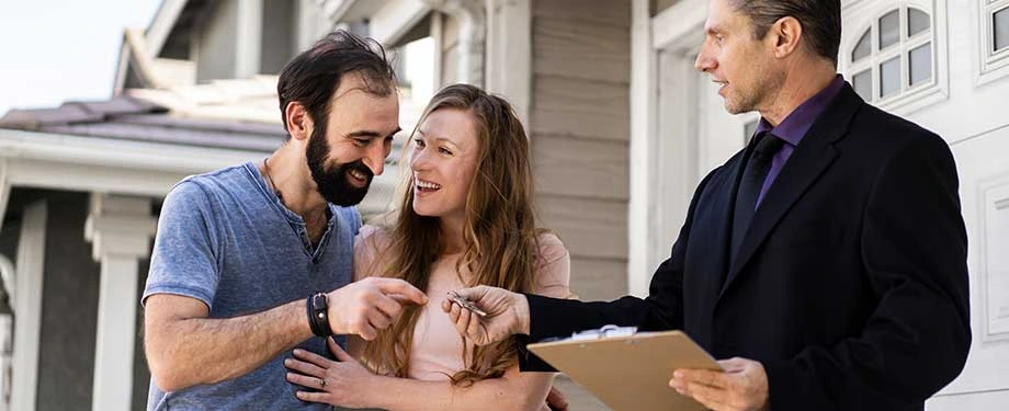 Sou obrigado a pagar seguro do imóvel alugado? Na imagem, casal recebe chave de imóvel alugado após apresentar seguro locação, que pode ser exigido em contratos de aluguel