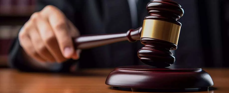 Qual o valor de um seguro garantia para leiloeiro? Na imagem, juiz com martelo da justiça representa seguro garantia leiloeiro, cujo valor depende de cada caso