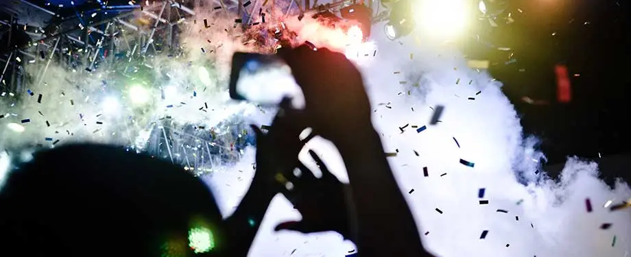 Quanto custa um seguro de evento? Na imagem, pessoa gravando show em alusão ao valor do seguro RC eventos, que depende de fatores como tipo e localização do evento