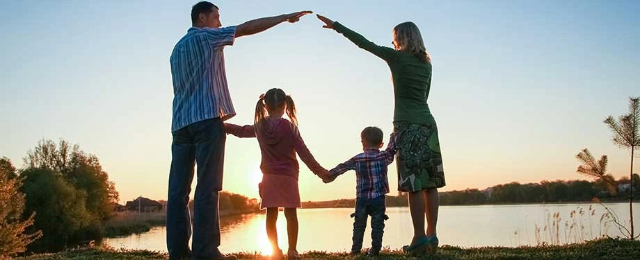 Quanto custa um seguro de vida familiar? Na imagem, família contempla o pôr do sol, representando a segurança e a tranquilidade possibilitadas pela contratação do seguro de vida