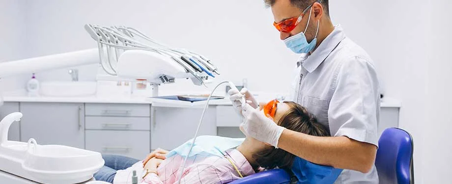 Paciente do sexo feminino realiza limpeza dentária em clínica odontológica, representando o seguro para clínica odontológica
