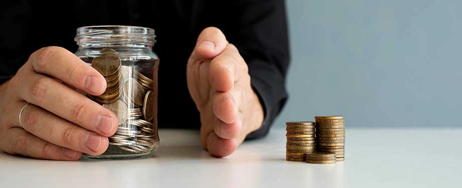 Qual banco faz depósito judicial? Na imagem, homem segurando pote de vidro com moedas em alusão aos bancos que possibilitam o depósito recursal