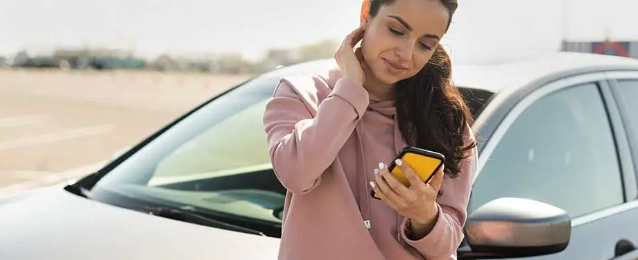 Como funciona o acionamento do seguro? Na imagem, mulher que contratou a apólice utiliza celular para acionar o seguro